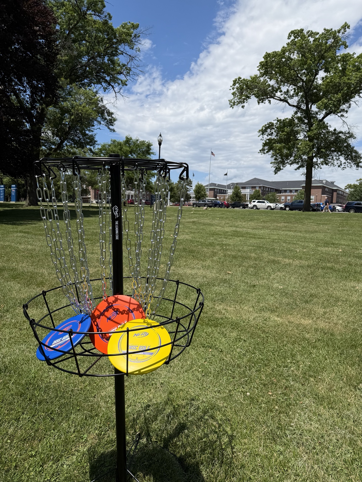 A portable disc golf basket and colorful discs on the grounds of the Battle Creek VA Medical Center